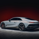 A very expensive gray coupe lurks extra lurkfully in front of a blood-colored background. Spooky!